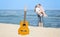 Portrait of young man and woman on a beach and guitar