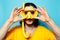 Portrait of young man in yellow, wearing diving mask and snorkel on background of blue color.