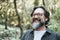 Portrait of young mature man alone smiling outside with nature trees in background. Environment. Happy people enjoying outdoor