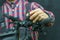 Portrait of a young mechanic in a plaid shirt on a black background in the process of work. A bicycle mechanic holds a tool and a