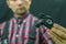 Portrait of a young mechanic in a plaid shirt on a black background in the process of work. A bicycle mechanic holds a tool and a