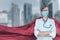 Portrait of young medical doctor hero woman with super person red cape protect city