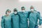 Portrait of young medical workers looking at camera inside hospital corridor - Main focus on right man face