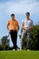 Portrait of young men standing with golf sticks on golf course