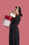 Portrait of young middle-eastern woman holding stack of gift boxes. Receiving lot of presents. Romantic surprises