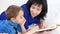 Portrait of a young mother and child. Family concept. Mom reads a book to her son in the nursery.