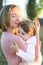 Portrait of young mother hugging little daughter and smiling.