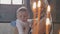 Portrait of young mother with little son in front of candles in church