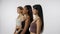 Portrait of young multiethnic models on white background close up. Group of three appealing multiracial girls standing