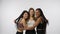 Portrait of young multiethnic models on white studio background close up. Group of three appealing multiracial girls