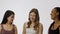 Portrait of young multiethnic models on white studio background close up. Group of three appealing multiracial girls