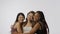 Portrait of young multiethnic models on white studio background close up. Group of three appealing multiracial girls