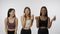 Portrait of young multiethnic models on white studio background close up. Group of three multiracial girls posing at the
