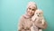 Portrait of Young muslim woman kisses and hugs her dog over green background