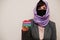 Portrait of young muslim woman wearing formal wear, protect face mask and hijab head scarf, hold The Gambia flag card against