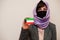 Portrait of young muslim woman wearing formal wear, protect face mask and hijab head scarf, hold Kuwait flag card against isolated
