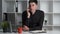 Portrait of a young office worker manager sitting at his desk and talking to customers