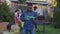 Portrait of young overburdened African American man sighing holding tablet with relaxed friends cooking bbq at