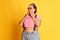 Portrait of young overweight woman in casual bright clothes posing over vivid yellow studio background. Beauty