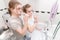 Portrait of a young pair of long-haired men and women brush their teeth with toothbrushes in the bathroom in front of a