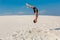 Portrait of young parkour man doing flip or somersault on the sand.