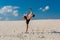 Portrait of young parkour man doing flip or somersault on the sand.