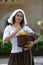 Portrait of a young peasant woman with a basket of products