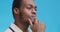 Portrait of young pensive african american doctor with contemplative face expressions, blue studio background