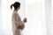 Portrait of young pregnant attractive woman, standing by the win