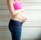 Portrait of a young pregnant woman holding stomach