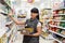 A portrait of young pretty Caucasian woman, an employee of a supermarket, is engaged in putting goods on display. Concept of