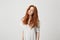 Portrait of young pretty girl with beautiful foxy hair looking at camera over white background.