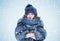 Portrait of a young pretty happy woman in a silver fox fur coat on a background of snow