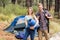 Portrait of a young pretty hiker couple holding a sleeping bag and backpack