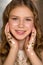 Portrait of young pretty teenager girl with golden freckles and star glitter on hands. Soft, selective focus.