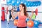 Portrait of a young pretty woman holding crossfit barbell and doing fitness indor. Crossfit hall. Gym shot.