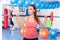 Portrait of a young pretty woman holding crossfit barbell and doing fitness indor. Crossfit hall. Gym shot.