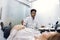 Portrait of young professional male African American doctor obstetrician, using ultrasound scanner and screening belly