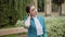 Portrait of young professional stewardess having neck pain. Tired slim Caucasian woman in blue uniform sitting outdoors