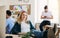 Portrait of young relaxed businesswoman with colleagues in a office, feet on desk.