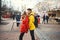 Portrait of young romantic couple in love kissing, hugging, walking on the street, wearning in bright down jackets