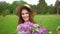 Portrait of young romantic smiling beautiful girl holding lilac in bouquet in nature forest outdoors looking at camera