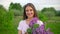 Portrait of young romantic smiling beautiful girl holding lilac in bouquet in nature forest outdoors looking at camera