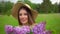 Portrait of young romantic smiling beautiful girl sniffing smelling lilac flowers in bouquet in nature forest