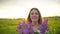 Portrait of young romantic smiling beautiful girl sniffing smelling lilac flowers in bouquet at sunset nature