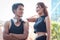 Portrait of young runner man and woman standing with arms akimbo outside, resting after exercise run outdoor, partner buddy runner
