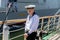 Portrait of young sailor in official marine uniform on the deck of the sailboat.