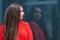 Portrait of a young sensual brunette in a red sweater by a polished dark marble wall