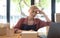 A portrait of young serious Asian woman working with laptop in the office full of packages and boxes stacking up, busy looking