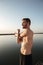 Portrait of a young shirtless sportsman warming up before jogging